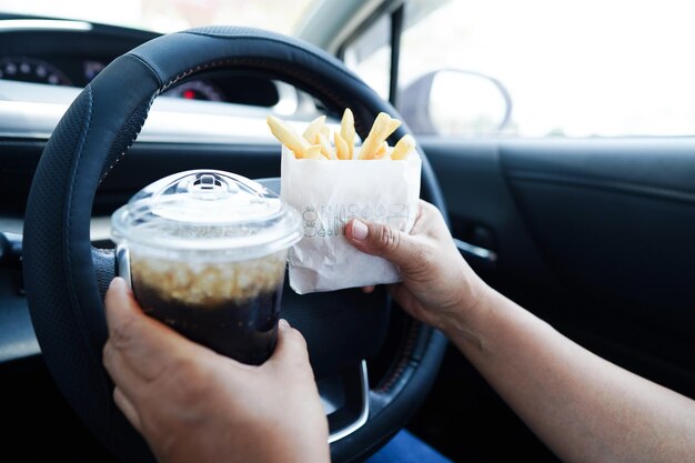 Motorista asiática segura e come batatas fritas no carro perigoso e arrisca um acidente