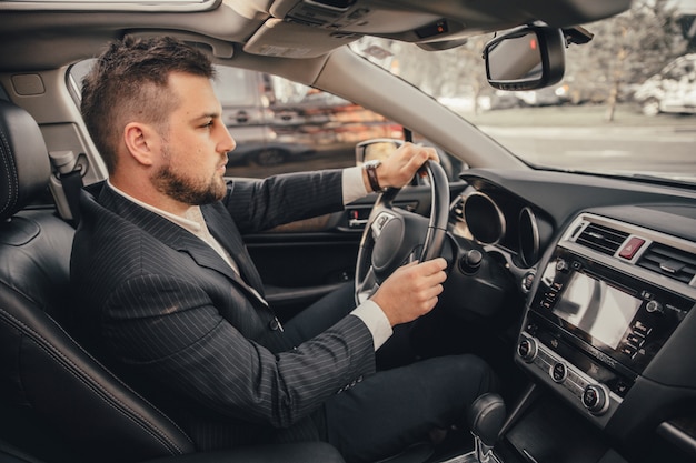 Motorista caucasiano bonito do empresário dentro no veículo