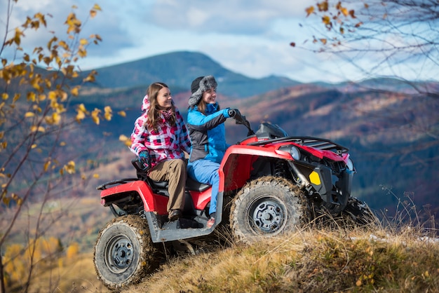 motorista de ATV de fêmeas em montanhas nevadas