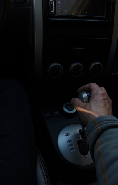 Foto motorista de carro dirigindo um carro com a mão na alavanca de engrenagem em automóvel