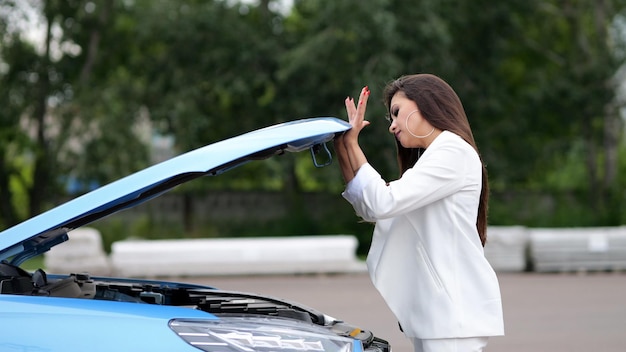 Motorista de empresária examina a condição do motor do carro