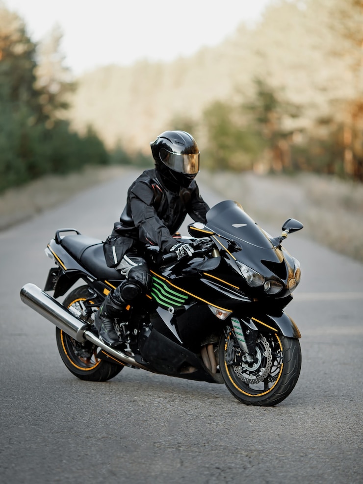 Foto motorista de motocicleta negra com capacete na estrada