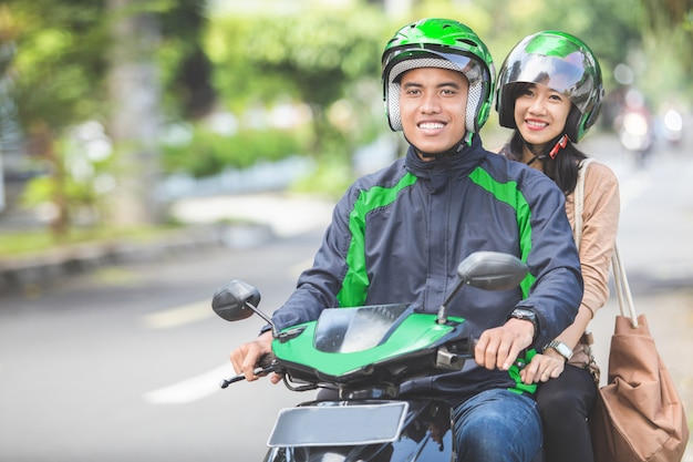 Motorista de táxi de moto comercial levando seu passageiro ao seu destino