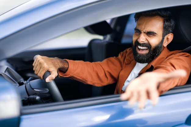 Motorista do Oriente Médio com raiva, homem a gritar a conduzir um carro em conflito