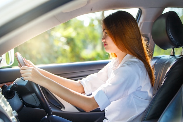 Motorista jovem mulher asiática dirigindo um carro na estrada na zona rural