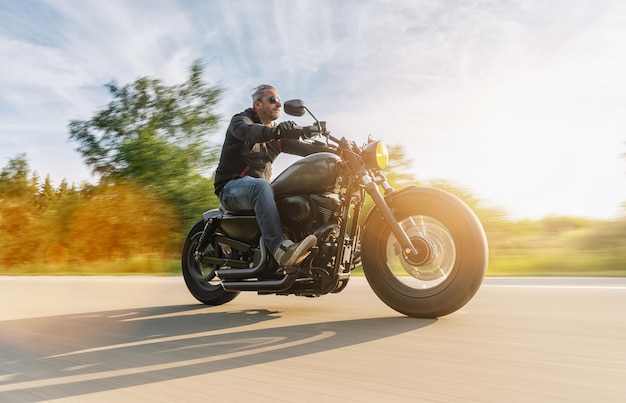 Motorrad-Chopper auf der Straße fahren. Spaß haben, auf einer Motorradtour die leere Straße zu fahren