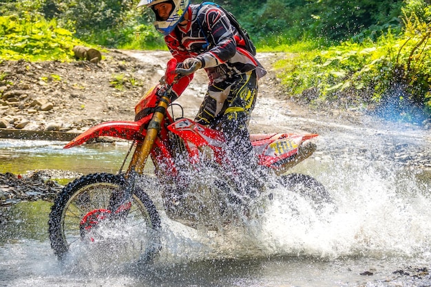 Motorrad Enduro und Athlet im Wasserspray