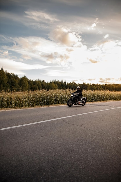 Motorradfahrer fährt bei Sonnenuntergang auf der Autobahn