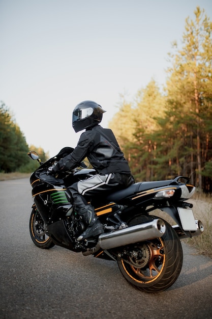 Motorradfahrer in einem Helm auf einem Motorrad auf einer Landstraße.