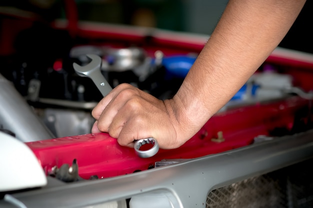 Motorreparaturtechniker halten den Schlüssel, um das Auto zu reparieren.