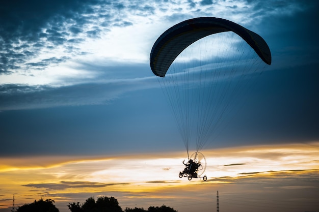 Motorschirmfliegen am Himmel bei Sonnenuntergang