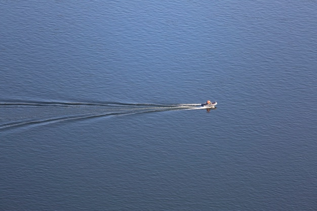 Foto motorschlauchboot auf einem hintergrund des blauen flusses draufsicht wasserbeschaffenheitshintergrund