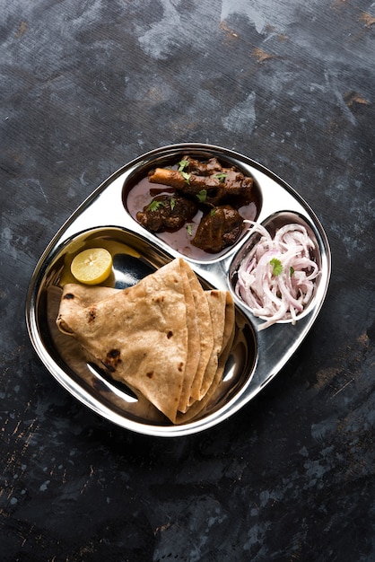 Motton Thali OR Gosht, Lamb Platter es un menú de almuerzo o cena no vegetariano asiático indio que consta de carne, huevo al curry con chapati, arroz, ensalada y dulce Gulab Jamun