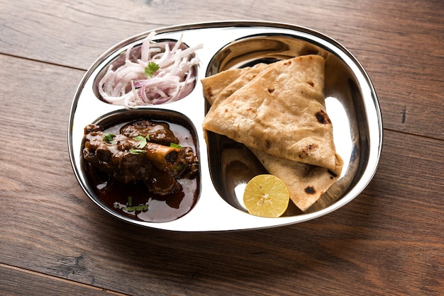 Motton Thali OU Gosht, prato de cordeiro é um almoço indiano asiático não vegetariano ou menu de jantar composto por carne, curry de ovo com chapati, arroz, salada e doce Gulab Jamun