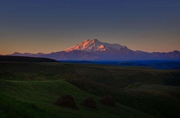 Mount Elbrus im Morgengrauen. Panoramablick auf die sonnenbeschienenen Hänge des Vulkans von Nordwesten