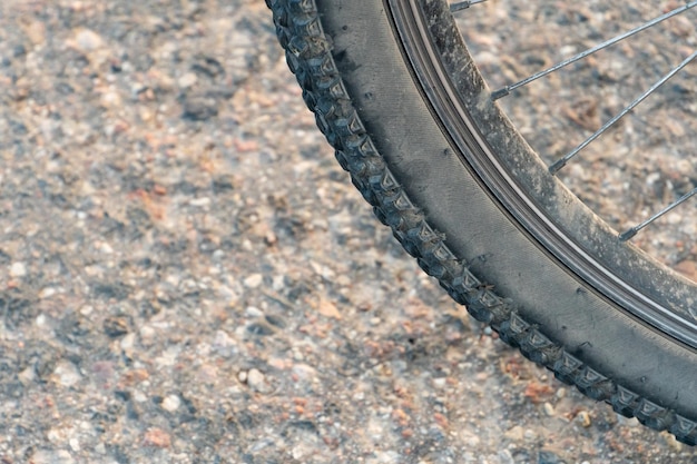 Mountainbike im Wald für Crosscountry-Wettkämpfe Hinterrad und Reifen eines Fahrrads sind Nahaufnahme vor dem Hintergrund einer unbefestigten Straße