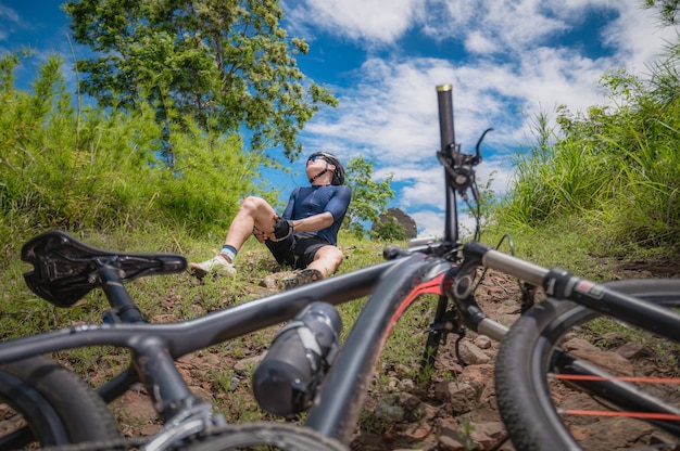 Mountainbiker fahren MTB, Mountainbike bergab verunglückt. Asiatischer Mann fährt MTB, Mountainbike-Downhill in freier Wildbahn hat einen Unfall. Bike Downhill Unfallkonzept.