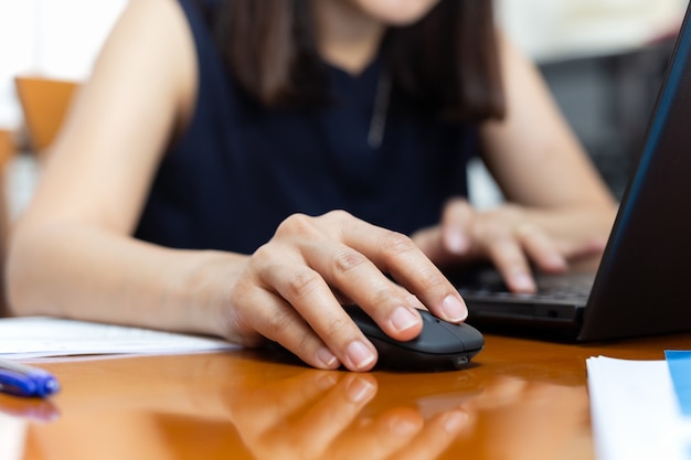 Foto mouse de clique de mão de mulher de negócios trabalhando com o laptop.