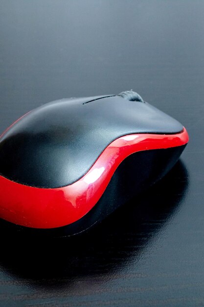 Mouse de computador preto em uma mesa de madeira