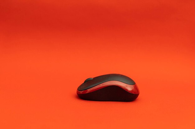 Mouse de computador preto sobre fundo vermelho