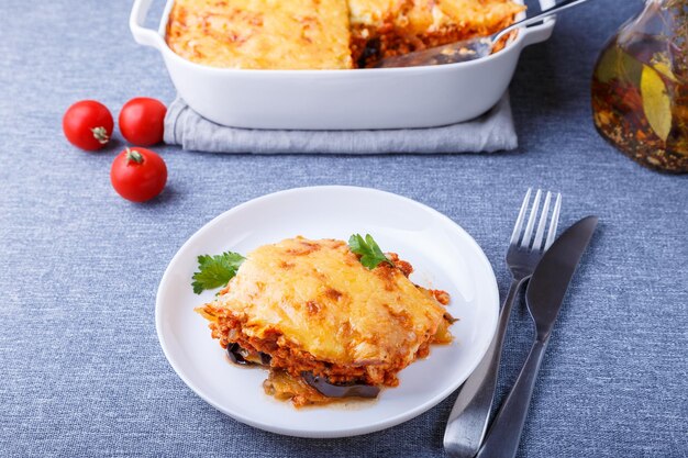 Moussaka mit Fleisch, Auberginen, Tomaten, Kartoffeln, Béchamelsauce und Käse auf einem weißen Teller Traditionelles griechisches Gericht Nahaufnahme