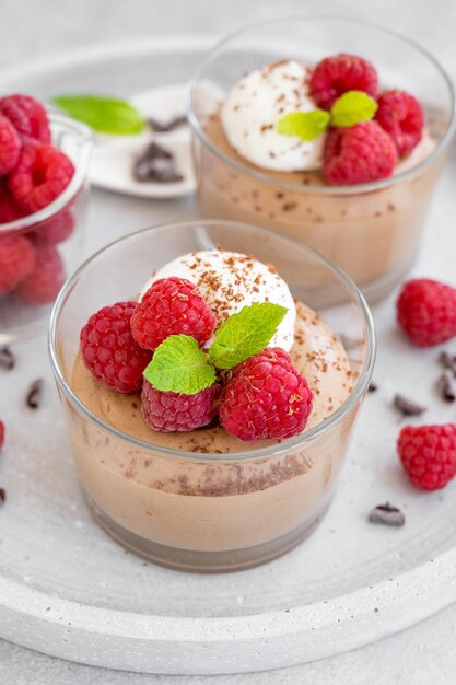 Mousse au Chocolat mit Schlagsahne und frischen Himbeeren in einem Glas kopieren