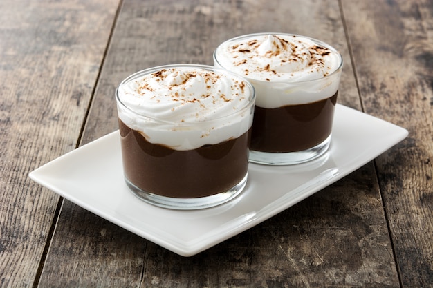 Mousse de chocolate en vasos en la mesa de madera