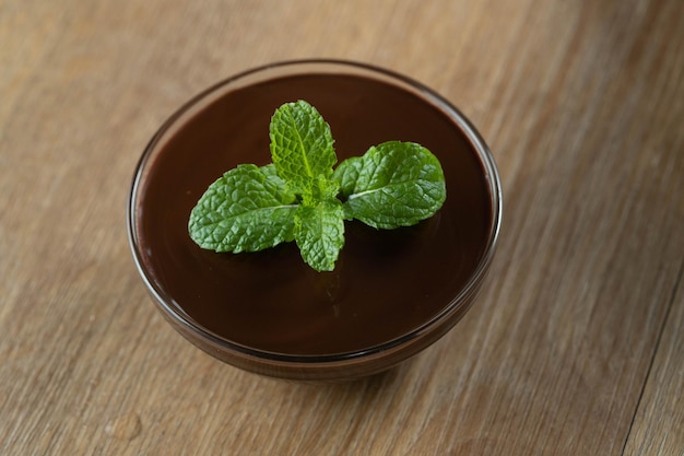 Mousse de calda de chocolate com hortelã em frasco de vidro na mesa de madeira