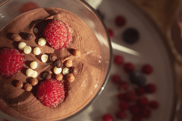 Mousse de chocolate com framboesas e morangos em uma sobremesa doce de vidro