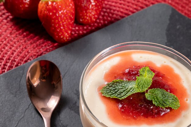 Mousse de limão em tigela de cristal com cobertura de geleia de morango e hortelã.