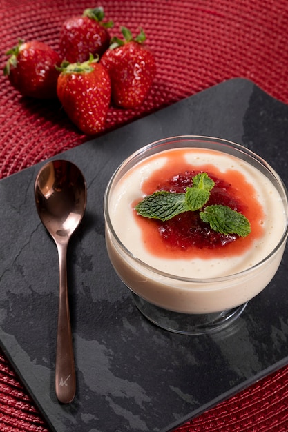 Mousse de limão em tigela de cristal com cobertura de geleia de morango e hortelã.