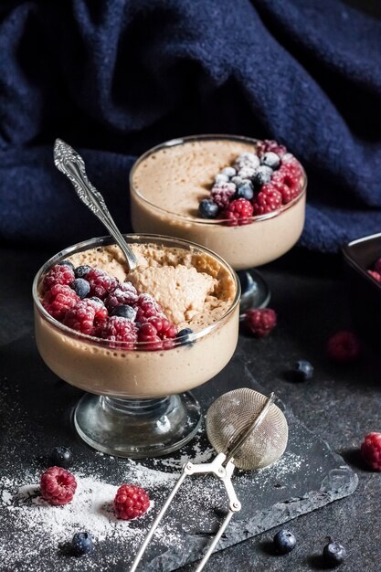 Mousse de Ryazhenka (leite fermentado) em taças de vidro decoradas com frutas frescas