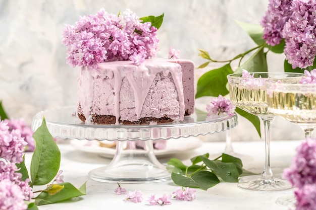 Mousse-Kuchen Köstliches Dessert Heidelbeer-Tarte mit frischen Beeren mit einem Strauß lila blühender Flieder Platz für Text