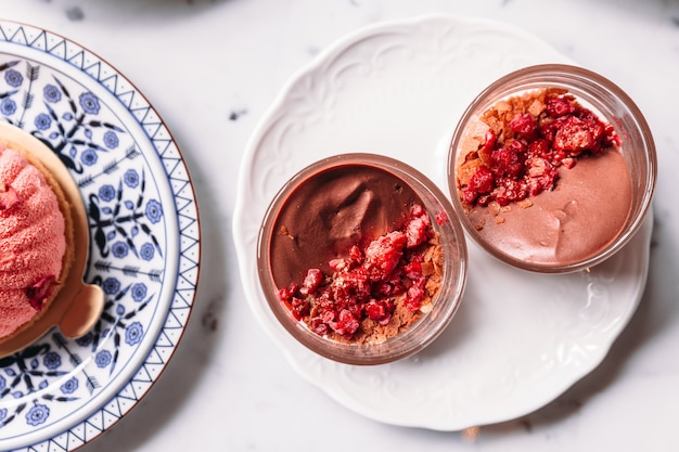 Mousse Rosa con Raspberry Cake Crumble servido en cristalería. Postre para el té de la tarde.