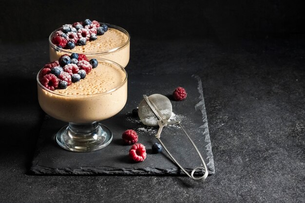 Mousse de ryazhenka (leche horneada fermentada) en cuencos de vidrio decorados con bayas frescas. Copia espacio