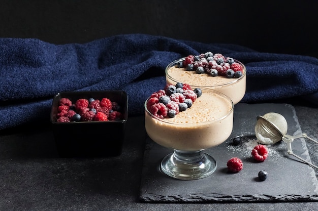 Mousse de ryazhenka (leche horneada fermentada) en cuencos de vidrio decorados con bayas frescas