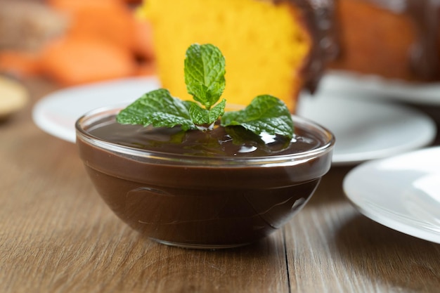 Mousse de salsa de chocolate con menta en tarro de cristal sobre mesa de madera