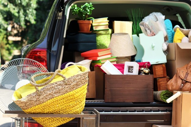 Movendo caixas e malas no porta-malas do carro ao ar livre