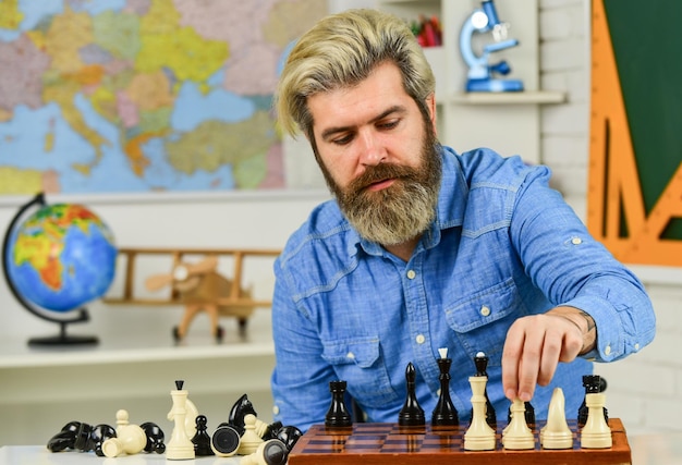 Foto movendo peças no tabuleiro de xadrez homem segura peça de xadrez homem concentrado desenvolvendo estratégia de xadrez jogando jogo de tabuleiro com amigo movendo peça durante torneio de xadrez