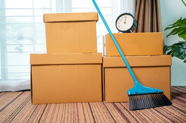 Mover cajas en apartamento nuevo y caja de cartón en el piso, concepto Move house.