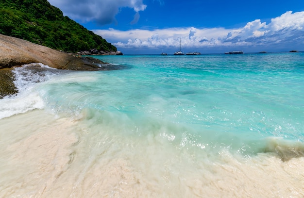 Movimento de areia branca e fina com mar claro com céu nublado e azul branco na ilha similan