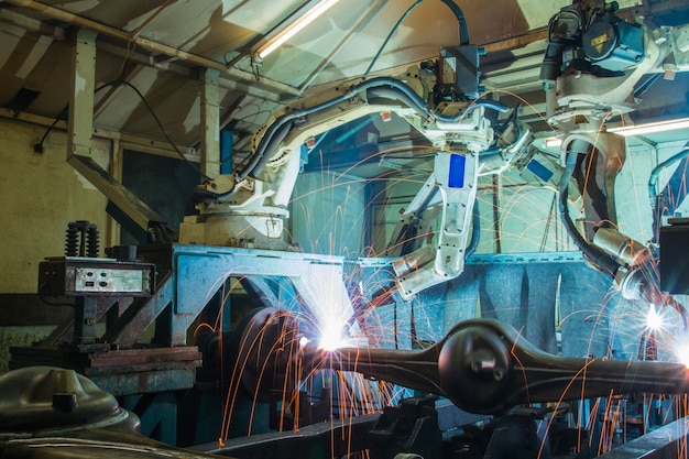 Foto movimento de soldagem de equipe robô parte automotiva industrial em fábrica