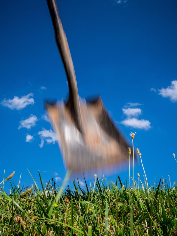 Foto movimento desfocado da pá sobre o campo contra o céu azul
