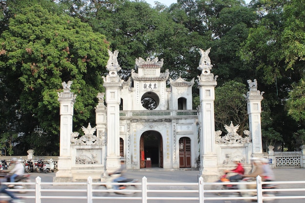 Movimento desfocado de pessoas em scooter contra o templo