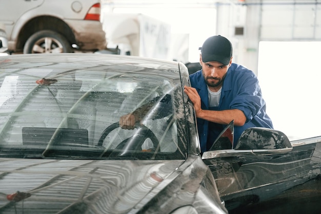 Movimento do carro sujo que precisa de lavagem Mecânico de automóveis trabalhando na garagem Serviço de reparação