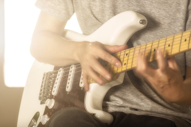 movimentos das mãos do homem novo que joga a guitarra elétrica com técnica de batida.