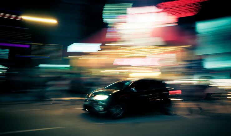 Foto movimiento borroso del coche en la calle de la ciudad por la noche