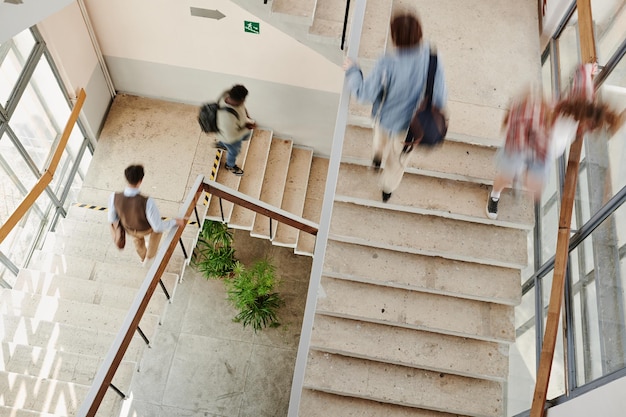 Movimiento borroso de estudiantes multiculturales de secundaria en escaleras