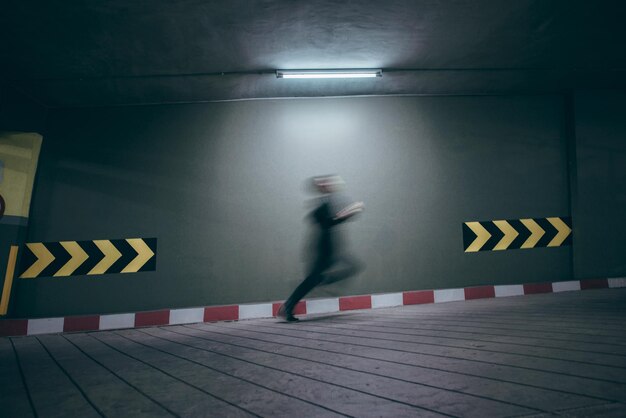 Foto movimiento borroso de un hombre corriendo en el estacionamiento