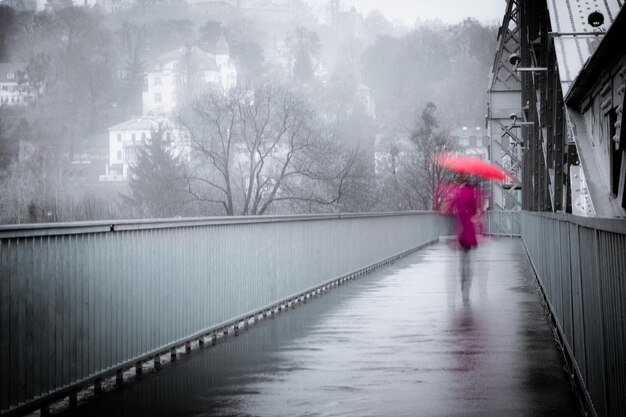 Movimiento borroso de una mujer caminando por el sendero durante la lluvia